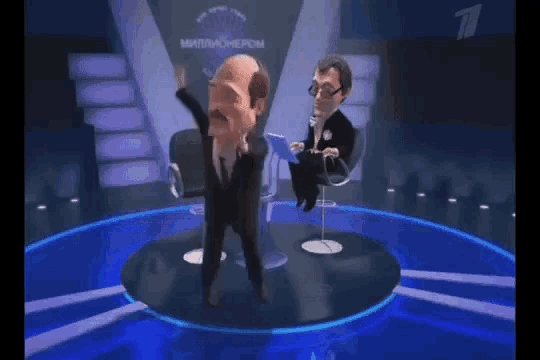 a man in a suit and tie is dancing in front of a man in a chair on a television show