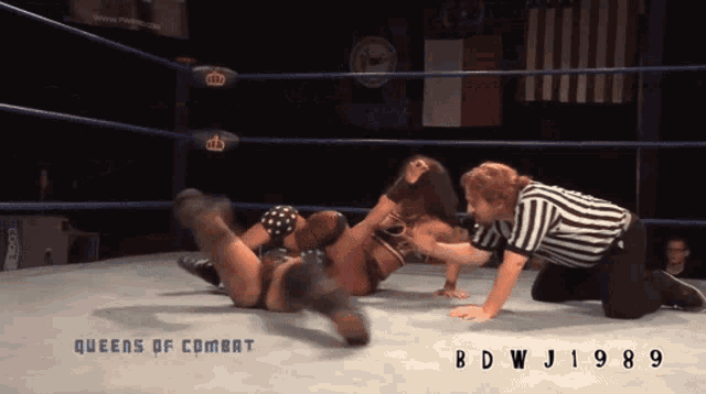 two women wrestling in a ring that says queens of combat on the bottom