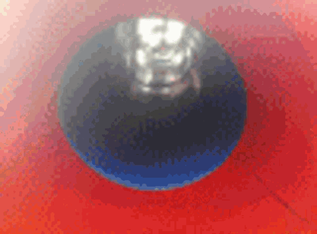 a close up of a red and blue ball on a red background .