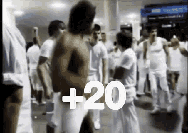 a blurred image of a group of people with the number +20 written in white