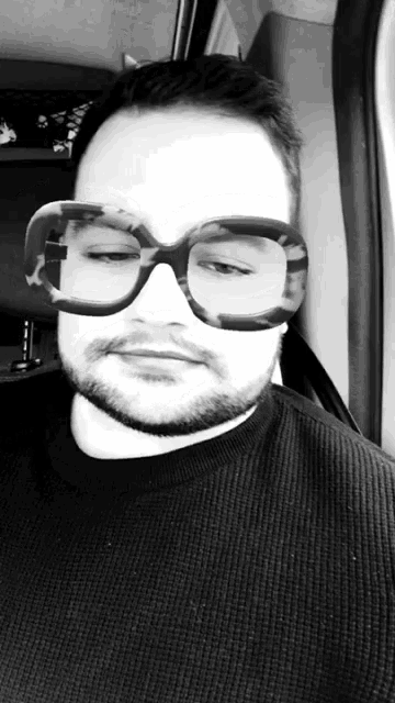 a man with a beard wearing a pair of large glasses