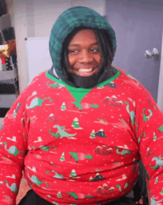 a man wearing a christmas sweater with a green hood