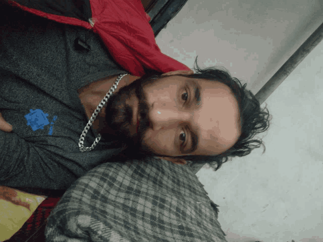 a man with a beard wearing a grey shirt that says ' do n't worry '