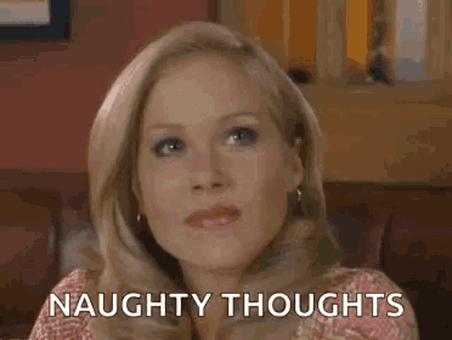 a woman is sitting on a couch with the words `` naughty thoughts '' on her face .