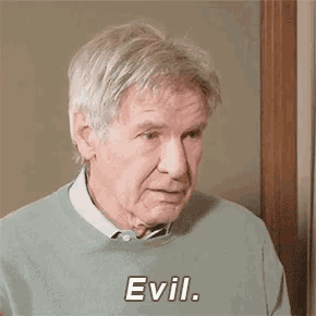 a man with gray hair is wearing a grey sweater and a white shirt and tie .
