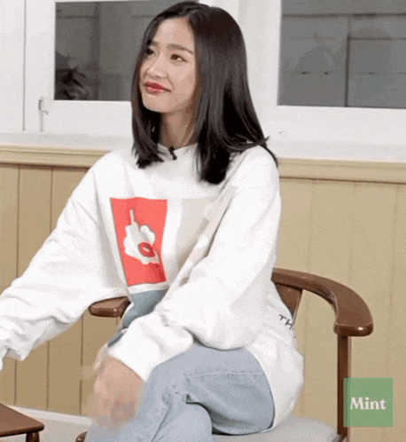 a woman is sitting in a chair with a mint sticker on the bottom