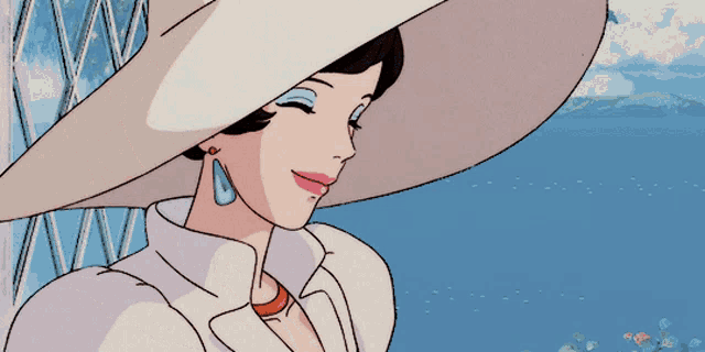 a woman wearing a white hat and earrings smiles in front of the ocean