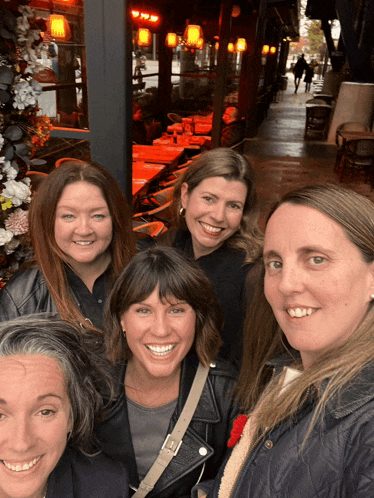 a group of women are posing for a picture and smiling