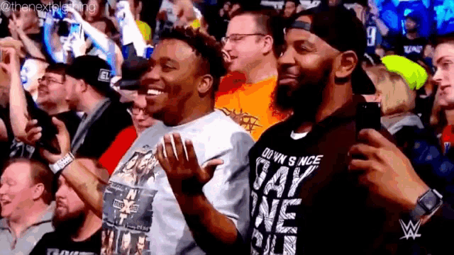 a crowd of people are watching a wrestling match in a stadium .