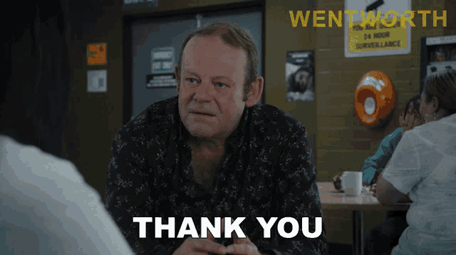 a man sitting at a table with a sign that says wentworth