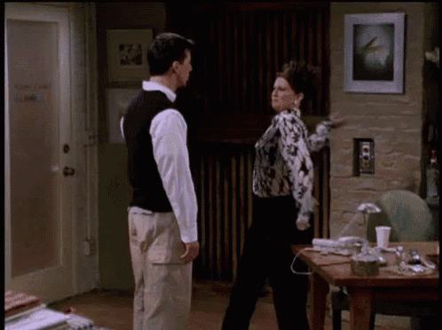 a man and a woman standing next to each other in a living room