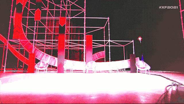a roller coaster is lit up at night with the hashtag # xf2021