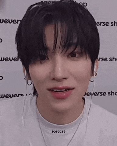 a close up of a young man wearing earphones and a necklace .