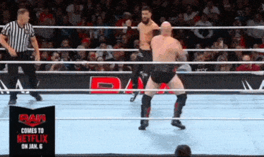 two men are wrestling in a wrestling ring with a sign that says raw comes to netflix on jan. 6 .