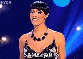 a woman in a black dress and necklace is standing on a stage with the words `` same parts '' written on the screen .