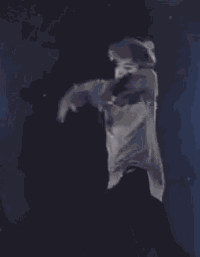 a man is standing on a stage holding a microphone and dancing .