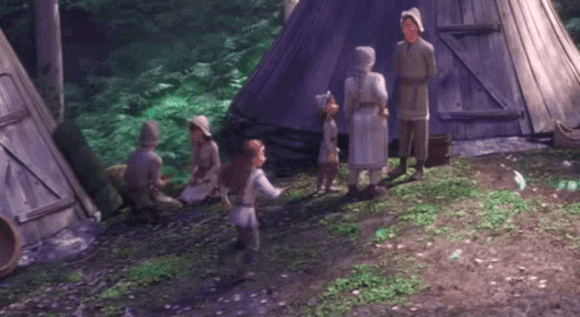 a group of people are standing in front of a group of tents in the woods .