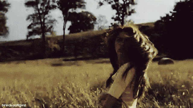 a gif of a woman standing in a field with the words breakoutgirls below her