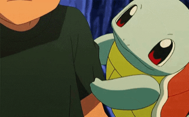 a man is holding a squirtle in his arms .