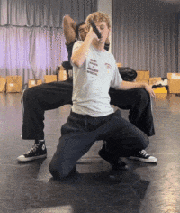 a man kneeling down with a gun in his hand and another man standing behind him