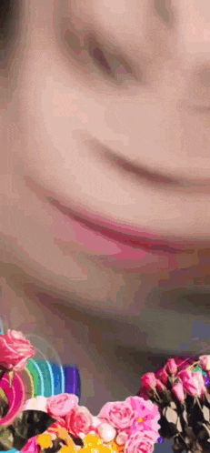 a close up of a person 's face with flowers in the background .