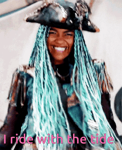 a woman with blue braids is wearing a pirate hat and smiling with the words " i ride with the tide " above her