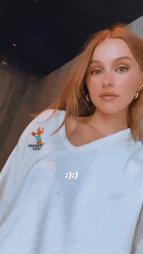 a woman is wearing a white sweatshirt with a cartoon character on it .