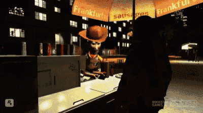 a man stands in front of a frankfurt sausage stand at night