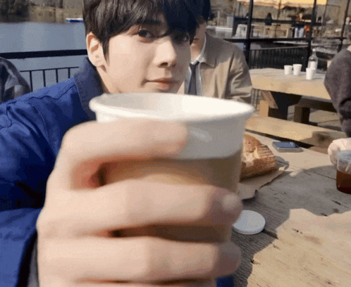 a man holding a cup of coffee in his hand