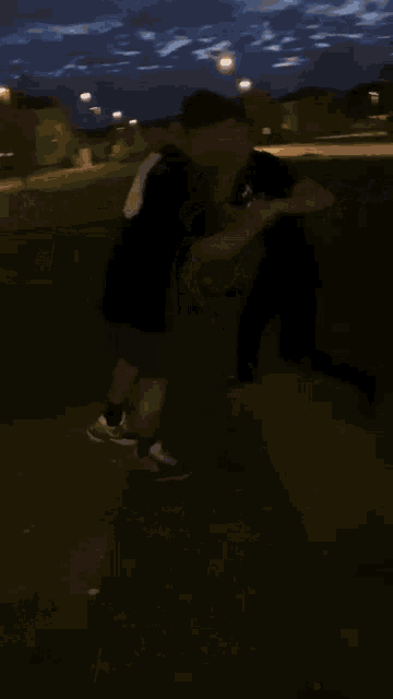 a blurry picture of a man drinking from a bottle at night