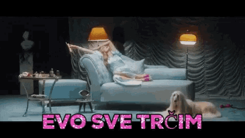 a woman laying on a couch next to a dog with the words evo sve trom written in pink