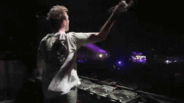 a man in a white shirt is playing music at a party