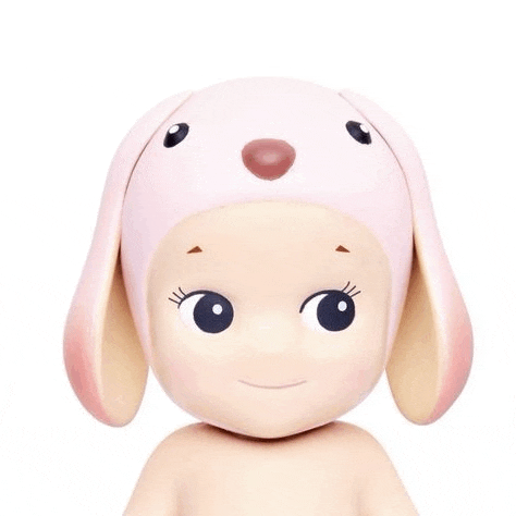 a close up of a doll wearing a pink hat with ears .