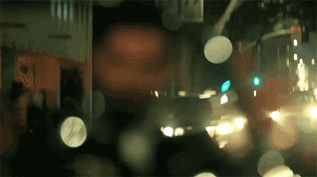 a blurry picture of a street at night with a sign that says ' n.y.c. ' on it