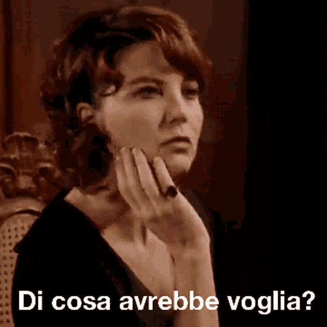 a woman is sitting in a chair with her hand on her chin and the words di cosa avrebbe voglia written on the bottom