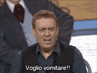 a man in a suit and tie is making a funny face and saying voglio vomitare !