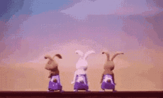 a group of three rabbits are standing next to each other on a wall .