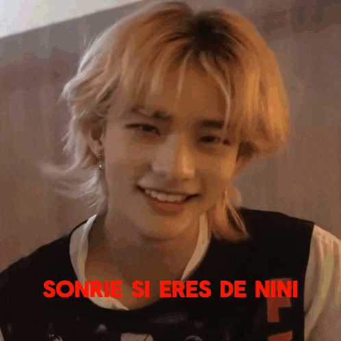 a close up of a person 's face with the words sonrie si eres de nini written in red