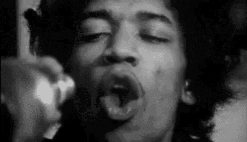 a black and white photo of a man with his mouth open and his tongue out .