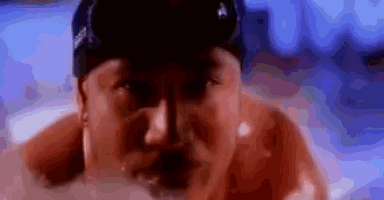 a close up of a man 's face in a hot tub with a hat on .