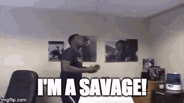 a man is dancing in a room with the words `` i 'm a savage '' above him .