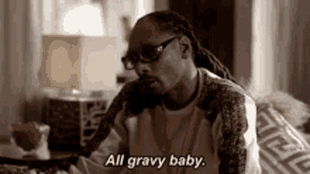 snoop dogg is sitting on a couch and says `` all gravy baby '' .