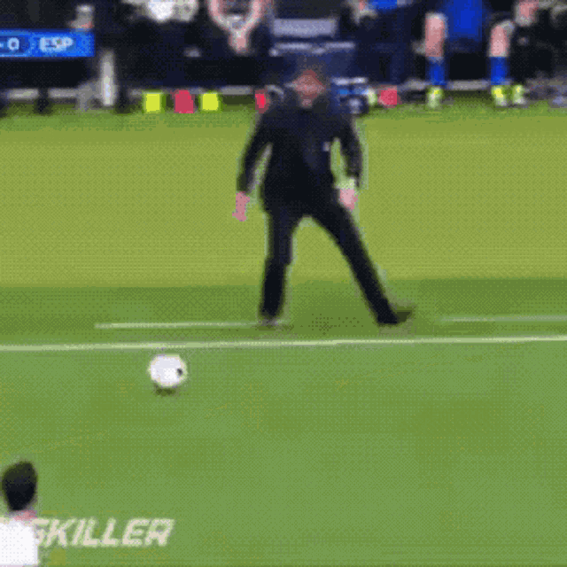 a man kicking a soccer ball on a field with skiller written on the side