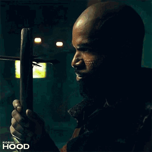a man is holding a wooden object with an arrow in it and the word robin hood on the bottom right