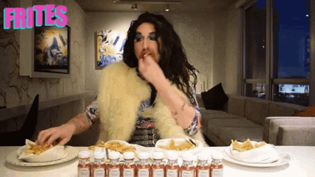 a drag queen is eating french fries with the word frites behind her