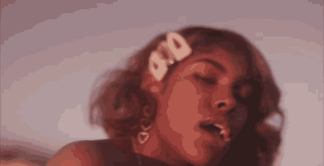 a close up of a woman 's face with a clip in her hair that says 000