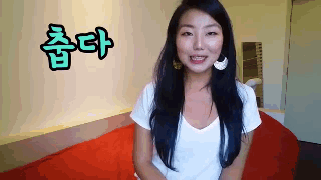 a woman sitting on a bed with korean writing on the wall