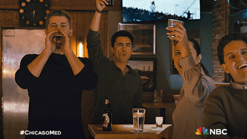 a group of people toasting in a bar with a nbc logo in the corner