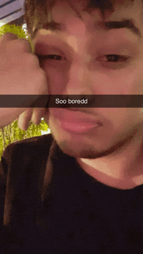 a man 's face is shown with a snapchat caption that says soo boredd