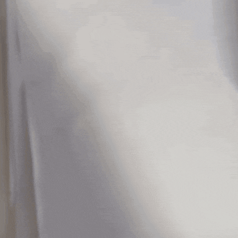 a blurred image of a person standing in a room with a white wall